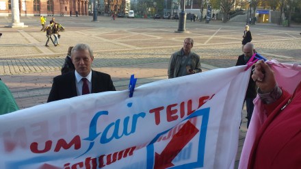 Stadtkämmerer trifft vor dem Rathaus auf UMfairTEILEN-Aufforderungen.