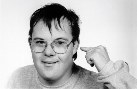 Michael Häger, Ohrenkuss-Autor, zeigt wie es geht: mit dem Zeigefinger der linken Hand zum linken Ohr hin und mit dem Daumen der rechten Hand vom rechten Ohr weg zeigen: “Da rein, da raus“. Quelle: @Ohrenkuss